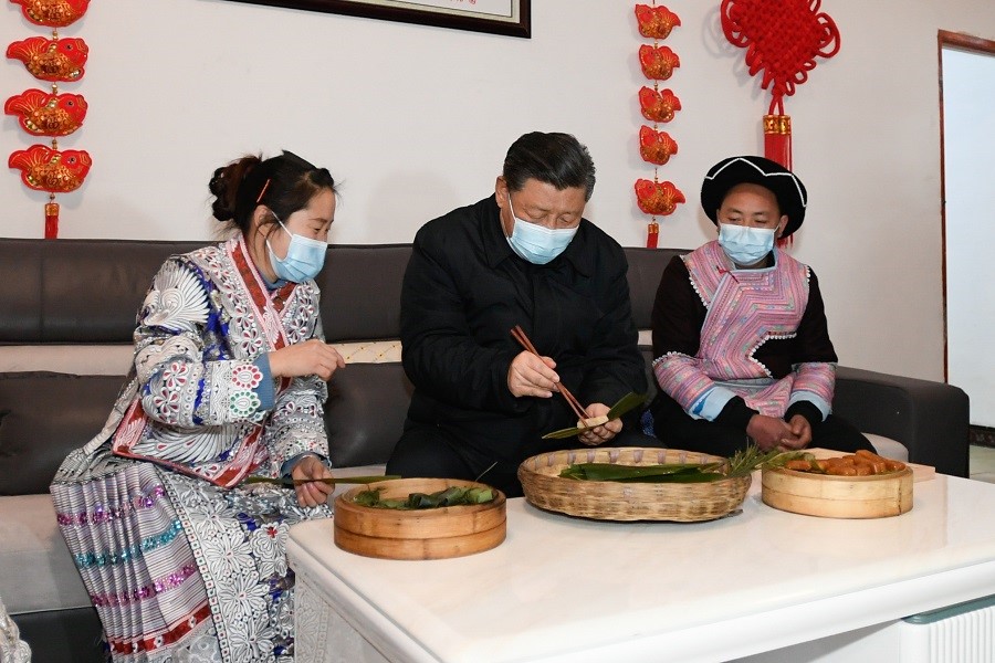 2021年2月3日下午，習(xí)近平在貴州畢節(jié)市黔西縣新仁苗族鄉(xiāng)化屋村苗族村民趙玉學(xué)家，同一家人邊聊家常邊制作當(dāng)?shù)貍鹘y(tǒng)節(jié)日食品黃粑。新華社記者 李學(xué)仁 攝