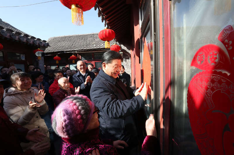 2019年2月1日上午，習(xí)近平在北京前門東區(qū)草廠四條胡同32號院，高興地拿起一幅“?！弊?，親自貼到門上，給這里的老街坊們拜年。新華社記者 鞠鵬 攝