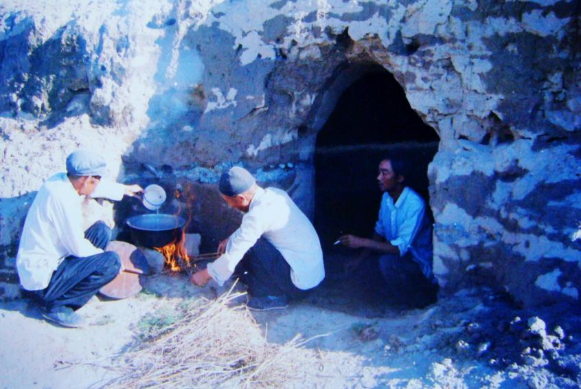 1983年，“六老漢”一代治沙人在“地窩子”生活做飯。新華社發(fā)（八步沙林場供圖）